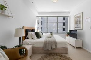 A bed or beds in a room at A Comfy 2BR Apt for 7 Next to Darling Harbour