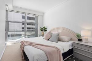 A bed or beds in a room at A Comfy 2BR Apt for 7 Next to Darling Harbour