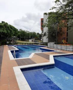 a large swimming pool with blue tiles on the ground at Apartamento en Cali Inn tropical CLO in Cali