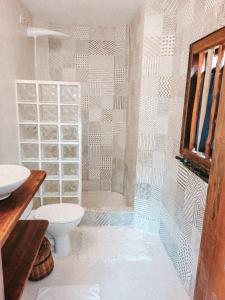 ein Bad mit einer Dusche, einem WC und einem Waschbecken in der Unterkunft Pousada Flor Do Mar in Caraíva