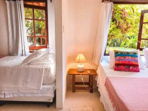 2 camas en una habitación con ventana en Pousada Flor Do Mar, en Caraíva