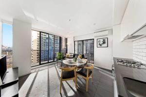 a kitchen and living room with a table and chairs at A Modern & Spacious 2BR Apt City Views Southbank in Melbourne