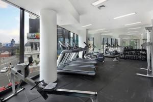 a gym with several treadmills and cardio machines at A Modern & Spacious 2BR Apt City Views Southbank in Melbourne