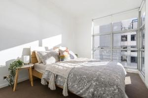 Un dormitorio con una cama y una ventana grande. en A Comfy 2BR Apt Amazing View of Darling Harbour, en Sídney 23 fotos más