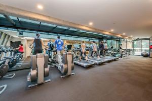 eine Gruppe von Personen, die in einem Fitnessstudio auf Laufbändern trainieren in der Unterkunft A Stylish CBD Studio Right Next to Southern Cross in Melbourne