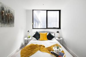 a bedroom with a bed with a yellow blanket on it at A Lux & Cozy 2BR Apt in the Heart of Chapel Street in Melbourne