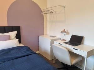 a bedroom with a bed and a desk with a laptop at maremar - Design im Zentrum - Luxus Boxspringbetten - Arbeitsplätze & Highspeed WLAN - Balkon in Braunschweig