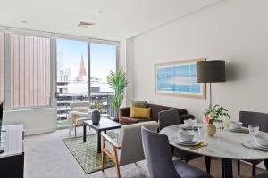 a living room with a table and a couch at A Cozy 2BR Apt on Collins Near Flinders Station in Melbourne