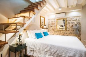 a bedroom with a white bed with blue pillows at Old Town City Center Apartments in Dubrovnik