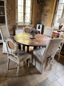 een eetkamer met een houten tafel en stoelen bij La périgourdine et son spa in Saint-Cyprien