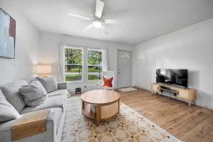 un soggiorno con un divano e una TV di Midtown Modern Cottage a Tyler