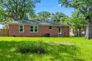 una casa in mattoni rossi con una recinzione e alberi di Midtown Modern Cottage a Tyler