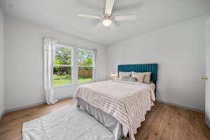 una camera da letto bianca con un letto e un ventilatore a soffitto di Midtown Modern Cottage a Tyler