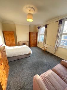 a bedroom with two beds and a couch at Sweet Homes in London