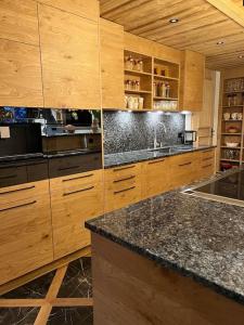 a kitchen with wooden cabinets and a granite counter top at Chalet Riedhuus in Davos Wolfgang