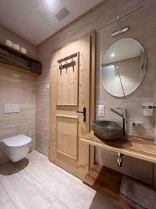 W łazience znajduje się umywalka, toaleta i lustro. w obiekcie Chalet Riedhuus w mieście Davos Wolfgang
