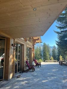 a porch with two purple chairs on a building at Chalet Riedhuus in Davos Wolfgang