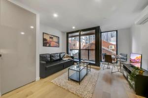 - un salon avec un canapé et une table dans l'établissement A Comfy 2BR Apt 5-Min Walk To Melbourne Central, à Melbourne