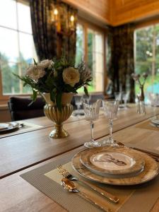 a wooden table with a plate and a vase of flowers at Chalet Riedhuus in Davos Wolfgang