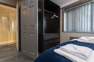 um quarto com uma cama e um armário com toalhas em Stylish House - Close to City Centre - Free Parking, Super-Fast Wifi and Smart TVs by Yoko Property em Middlesbrough