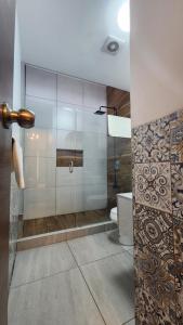 a bathroom with a glass shower with a toilet at Casa Madero 227 in Aguascalientes