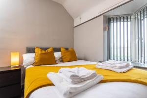 um quarto com uma cama com lençóis amarelos e brancos em Stylish House - Close to City Centre - Free Parking, Super-Fast Wifi and Smart TVs by Yoko Property em Middlesbrough