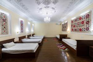 a row of beds in a room with a chandelier at EAST STAR in Khiva
