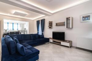a living room with a blue couch and a tv at Mare Vento I in Akrotiri