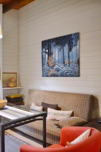 eine Couch in einem Wohnzimmer mit einem Gemälde an der Wand in der Unterkunft Cabaña Rural ¨La Huerta de los Serijos¨ in Fuente el Fresno