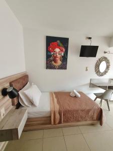 a bedroom with a bed with a painting on the wall at Studios Denis in Stavros