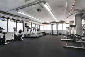 a gym with treadmills and machines in a room at A Cozy Apt Near Grand Prix Circuit FREE Parking in Melbourne