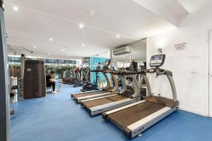 a gym with a row of treadmills and machines at A Large 2BR Apt Near Crown Sleeps 8 FREE Parking in Melbourne
