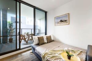 uma sala de estar com um sofá e uma mesa em A Stylish 2BR Apt Near Melbourne Central em Melbourne