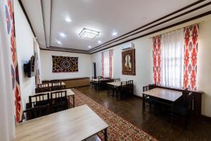 a dining room with tables and chairs and curtains at EAST STAR in Khiva