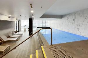 a large swimming pool in a building with a swimming pool at A Modern Apt Near Southern Cross with City Views in Melbourne