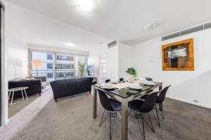 a living room with a dining table and chairs at A Comfy 2BR Apt Right Next to Darling Harbour in Sydney