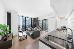 a living room with a couch and a table at A Stylish 2BR Apt with City Views in Southbank in Melbourne
