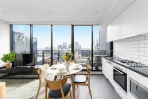 a kitchen and dining room with a table and chairs at An Amazing 2BR Apt with City Views in Southbank in Melbourne