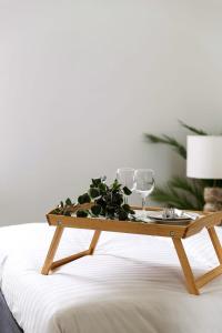 Una mesa de centro de madera con vasos y una planta sobre una cama. en A Lux 2BR Apt Next to Melbourne Uni FREE Parking, en Melbourne 21 fotos más