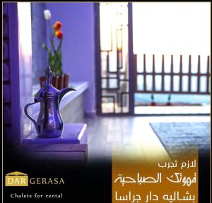杰拉什Dar Gerasa chalets - شاليهات دار جراسا的坐在门前桌子上的蓝色花瓶
