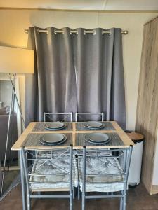 a table with two chairs and a curtain at Three bedroom holiday home in Whitstable