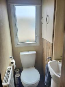 a small bathroom with a toilet and a sink at Three bedroom holiday home in Whitstable