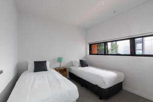 a bedroom with two beds and a window at A 3BR Apt Next to Melbourne Zoo FREE Parking in Melbourne