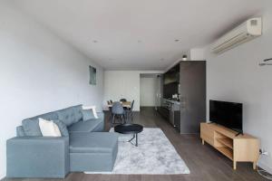a living room with a blue couch and a table at A 3BR Apt Next to Melbourne Zoo FREE Parking in Melbourne