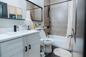 a bathroom with a toilet and a sink and a tub at The Brown House - A luxurious UChicago Campus stay in Chicago