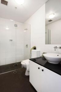 a white bathroom with a sink and a toilet at A Plush & Comfy Apt Right Next to Darling Harbour in Sydney