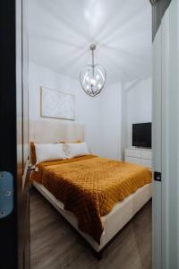 1 dormitorio con cama y lámpara de araña en The Brown House - A luxurious UChicago Campus stay, en Chicago