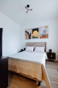 1 dormitorio con 1 cama y pinturas en la pared en The Brown House - A luxurious UChicago Campus stay, en Chicago