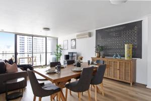 墨尔本A 3BR Apt Next to Southern Cross FREE Parking的一间带桌椅和黑板的用餐室