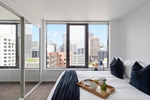 墨尔本A 3BR Apt Next to Southern Cross FREE Parking的卧室里有一张白色的大床，还有一扇大窗户 更多15张照片